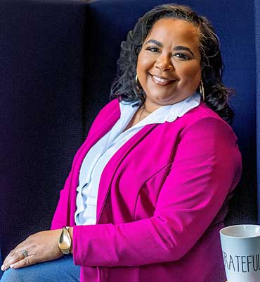 Angela Caliver The Collective Genius headshot in a hot pink blazer